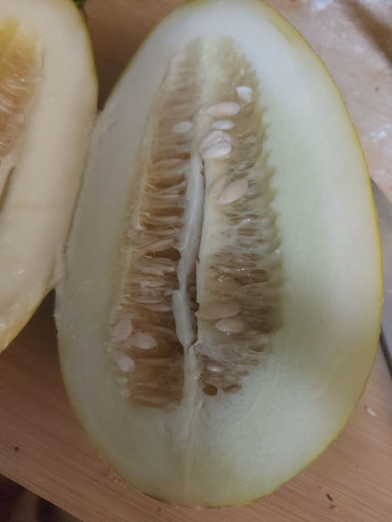 Halved melon on a wooden cutting board